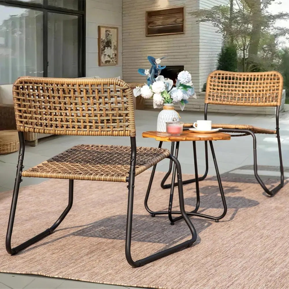 Wicker chairs and a small table on a patio with a house in the background