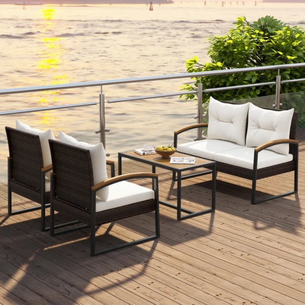 Outdoor furniture set with chairs and a table on a wooden deck by a body of water.
