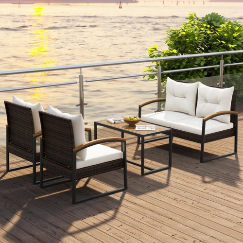 Outdoor furniture set with chairs and a table on a wooden deck by a body of water.