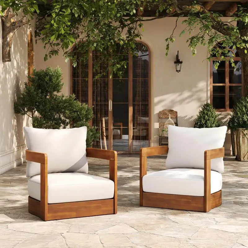 Two wooden chairs with white cushions on a stone patio