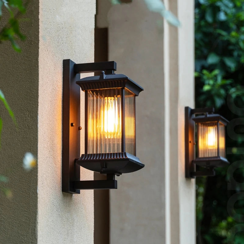 Two outdoor wall lights on a building exterior with a warm glow.