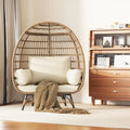 Wicker egg-shaped chair with cushions in a room with wooden furniture.