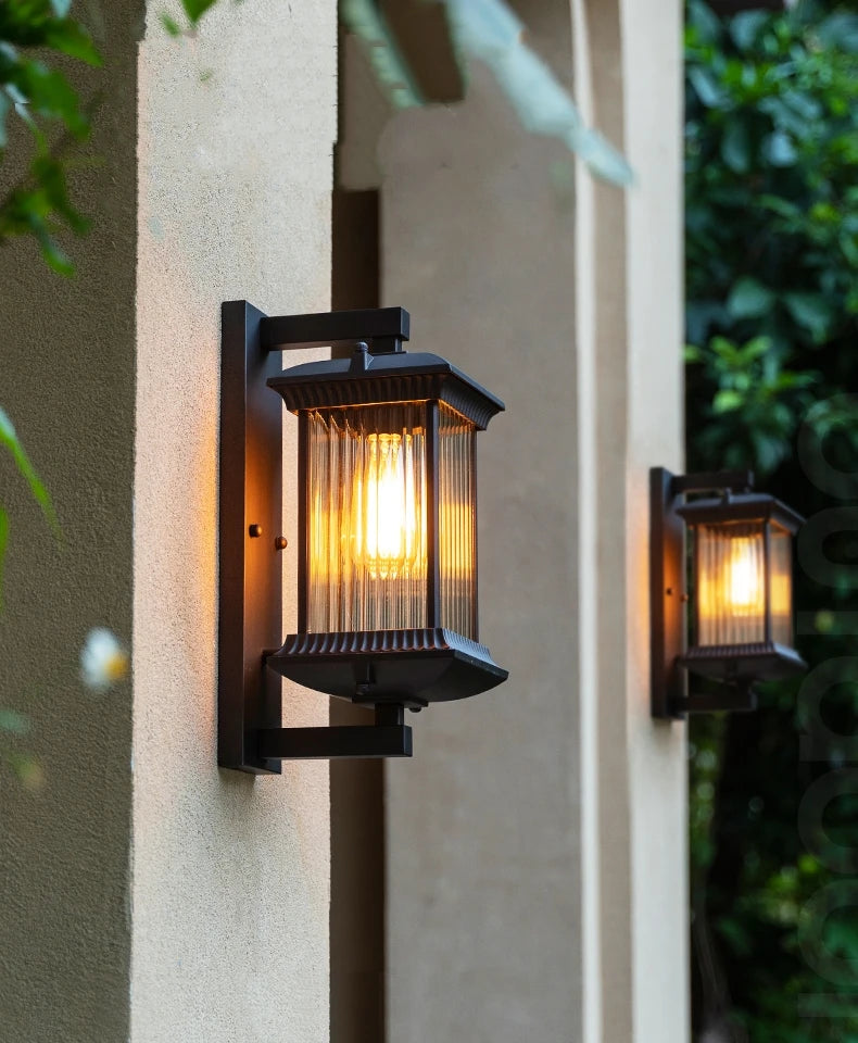 Two outdoor wall lights on a building exterior with a warm glow.