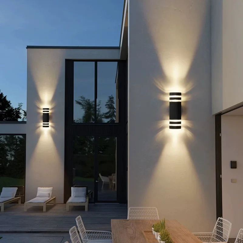 Modern outdoor wall lights on a house exterior with patio furniture.