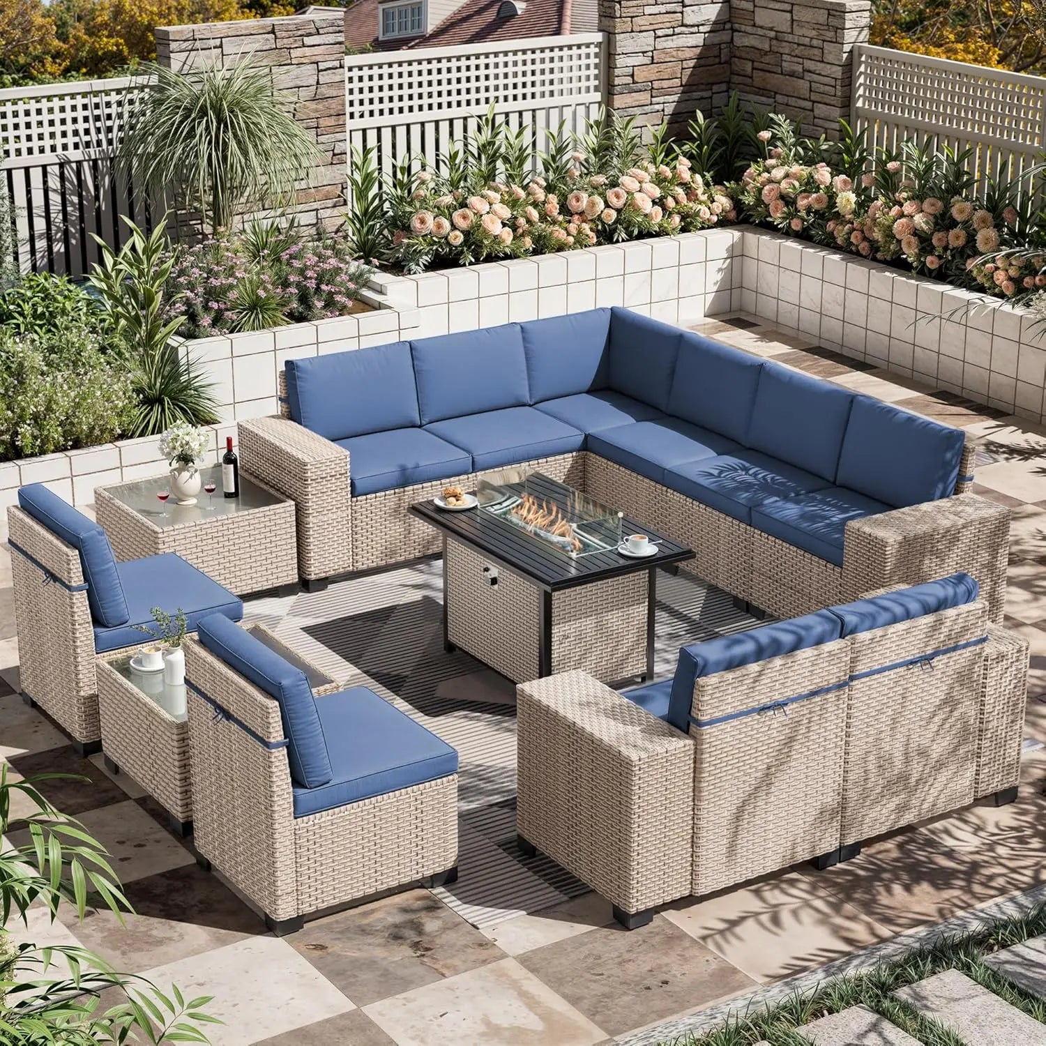 Outdoor patio furniture set with blue cushions on a patio with plants and flowers.